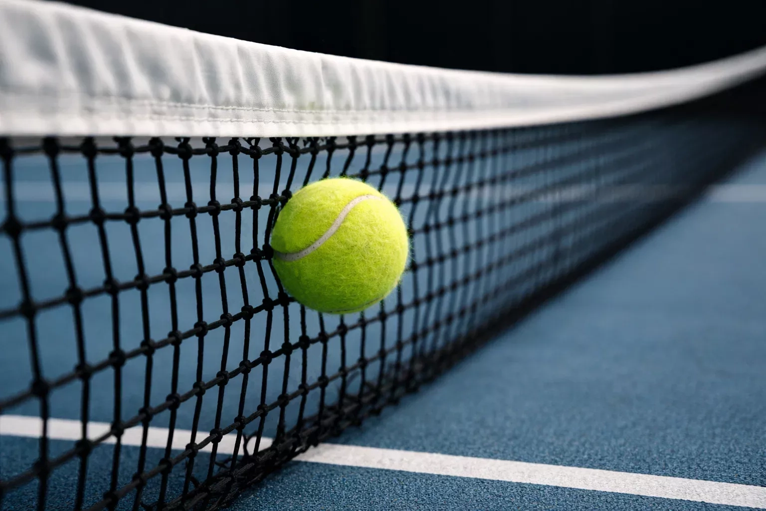 Tennisball prallt am Netz ab und fällt zurück – symbolisch für einen Fehler