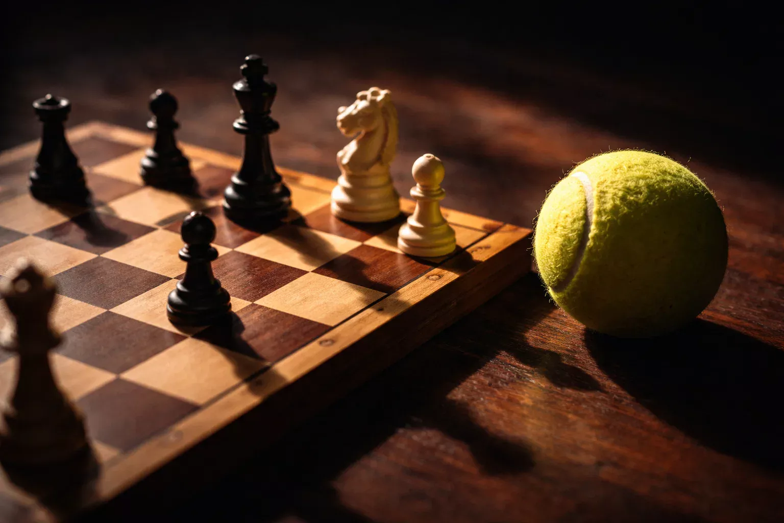 Schachbrett neben einem Tennisball als Symbol für strategisches Denken